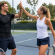 Two tennis players celebrating with Simtion carbon fiber tennis rackets on an outdoor court